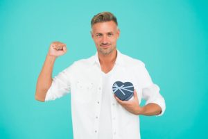 גבר מחייך מחזיק קופסא בצורת לב